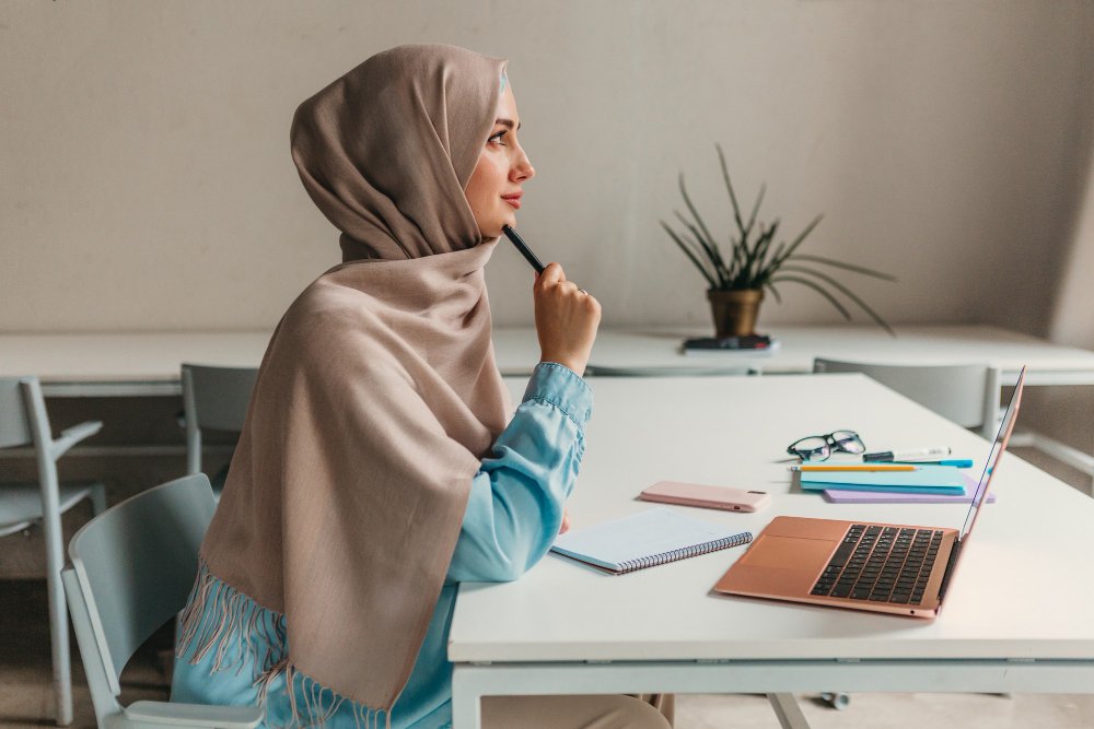 young-pretty-modern-muslim-woman-hijab-working-laptop-office-room-education-online